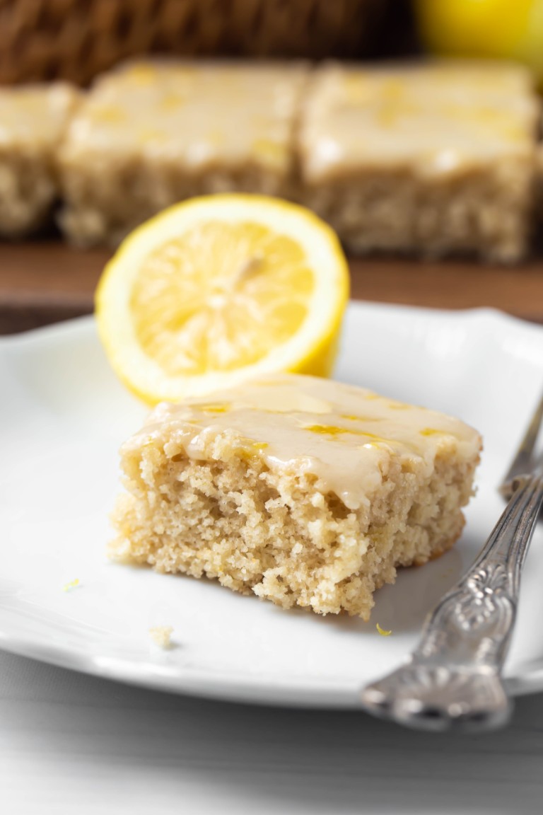 slice of lemon cake with fork on white plate
