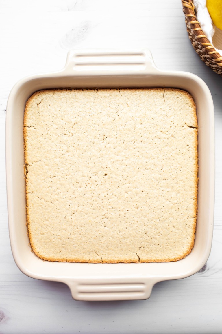 baked lemon cake golden brown along the edges in dish