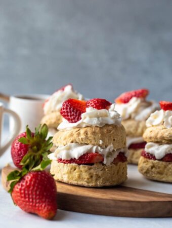 stacked shortcake with whipped cream and strawberries layers on biscuits