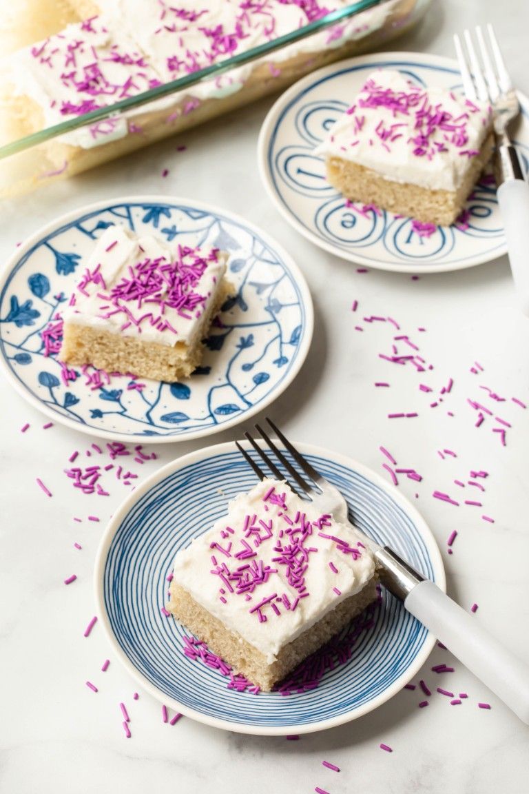 slices of vegan vanilla cake on blue plates with forks