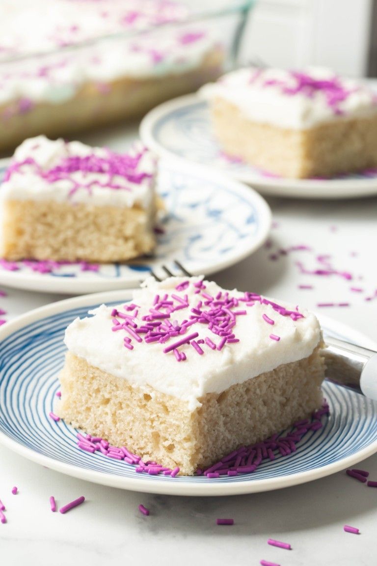 3 blue plates of vanilla cake slices and frosting and purple sprinkles