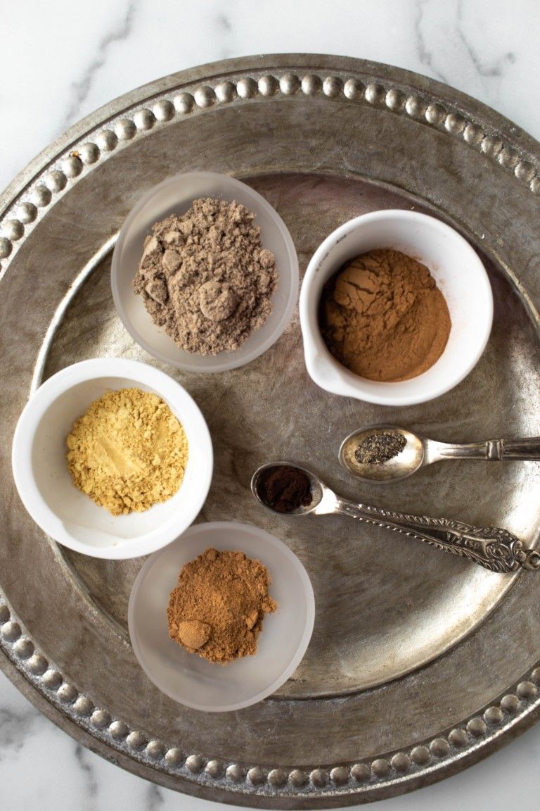 different chai spices in mini bowls on silver platter