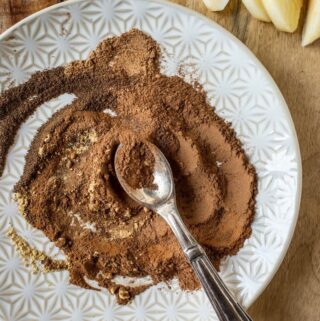 spices mixed together on white place with silver spoon