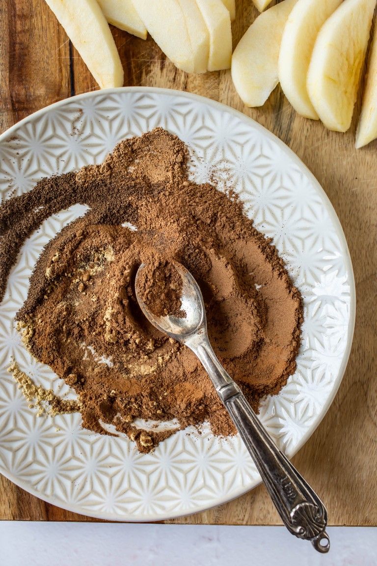 spices mixed together on white place with silver spoon