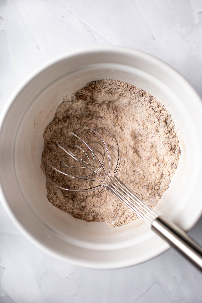 dry ingredients in white bowl with whisk