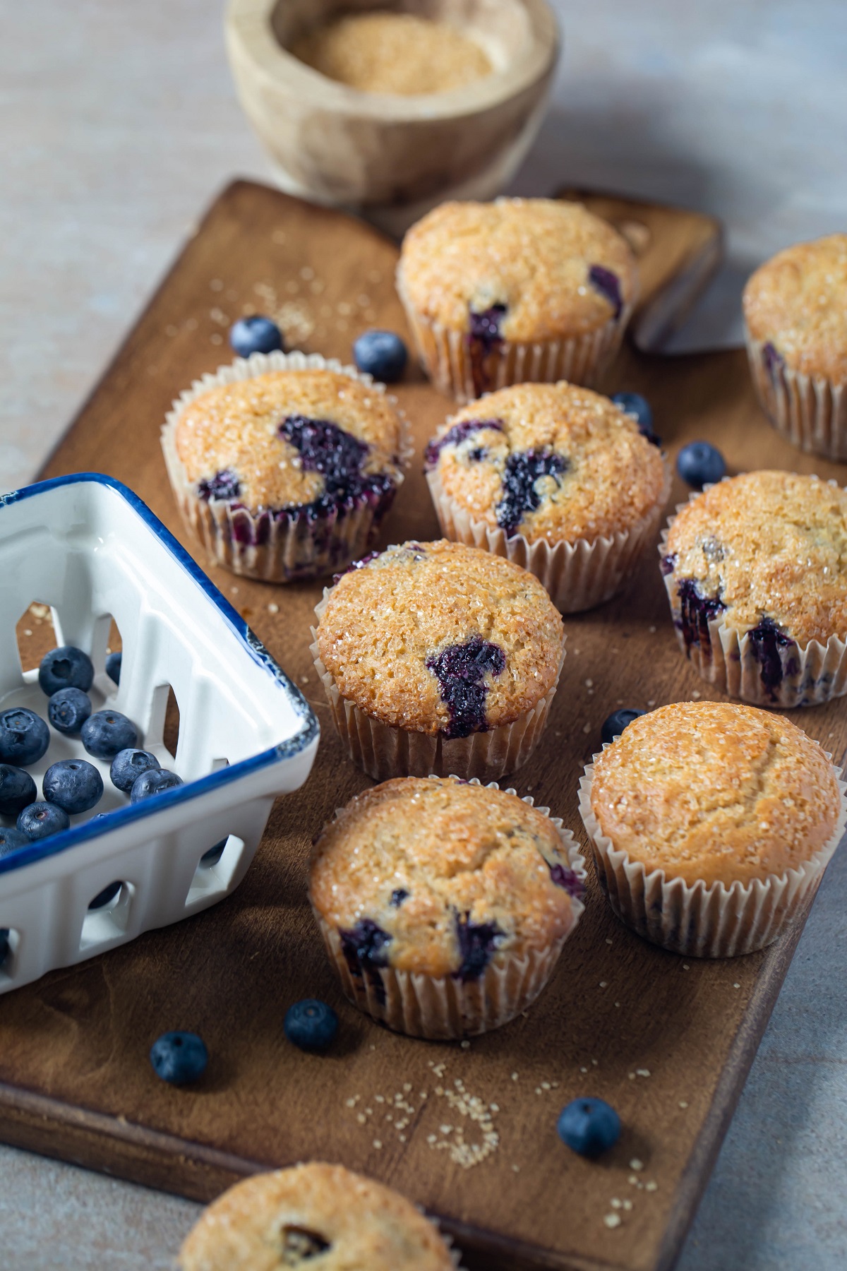 several vegan blueberry muffins on wood platter