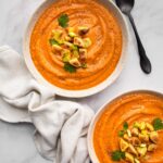 overhead shot of 2 white bowls of instant pot sweet potato soup with towel