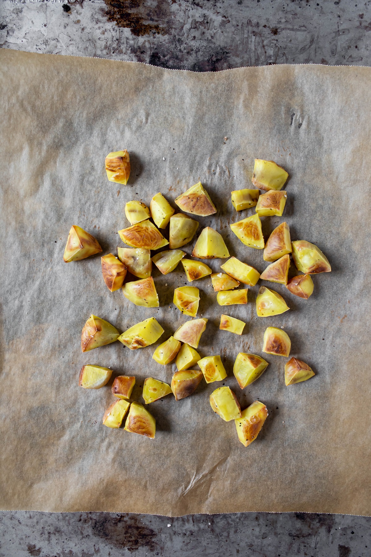 roasted yukon gold potatoes on parchment paper on sheet pan