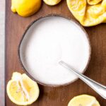 overheat shot of wood bowl of lemon sauce with fresh lemons and yellow towel