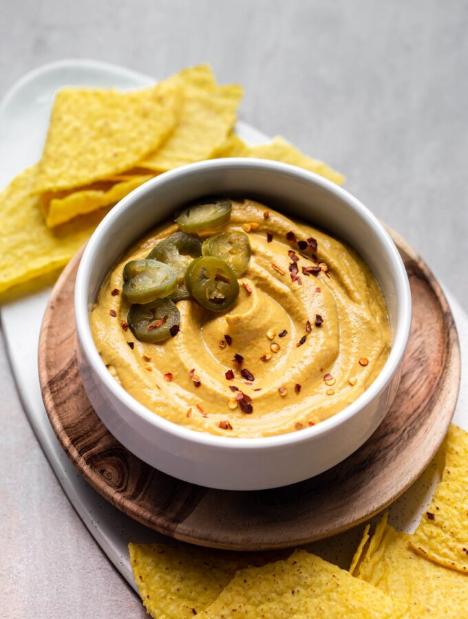 white bowl of vegan nut free queso with jalapeno slices